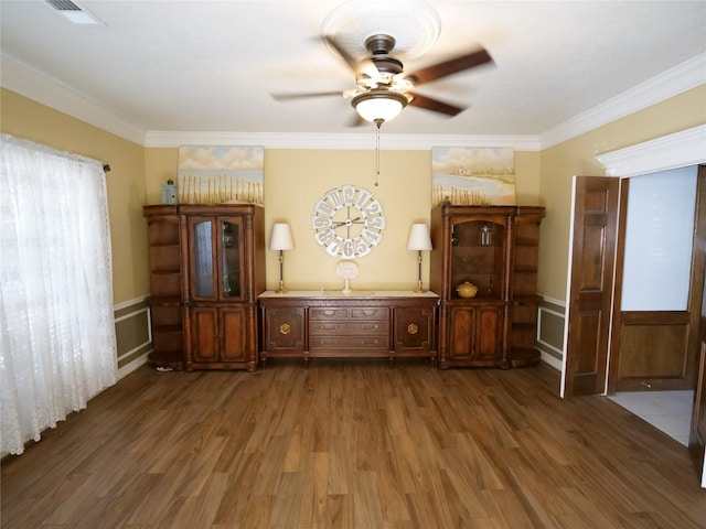 unfurnished dining area featuring ceiling fan, ornamental molding, and dark hardwood / wood-style floors