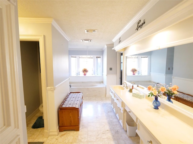 bathroom featuring ornamental molding, vanity, a washtub, toilet, and a textured ceiling