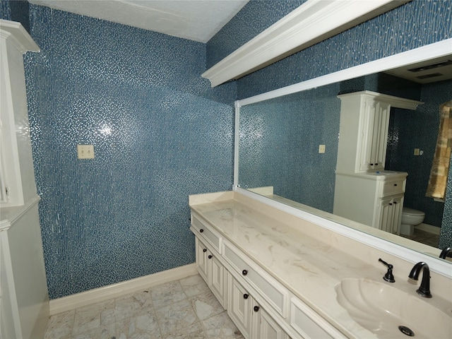 bathroom with ornate columns, vanity, and toilet