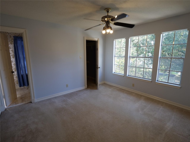 unfurnished bedroom with ceiling fan, light carpet, and a textured ceiling