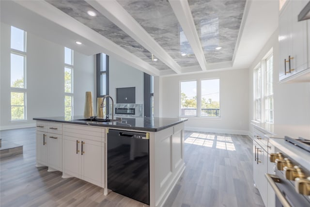 kitchen featuring high end stove, baseboards, open floor plan, white cabinets, and dishwasher