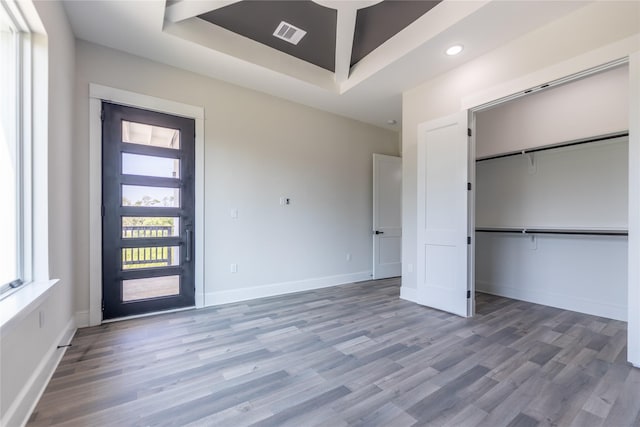 entrance foyer featuring recessed lighting, wood finished floors, visible vents, baseboards, and a raised ceiling