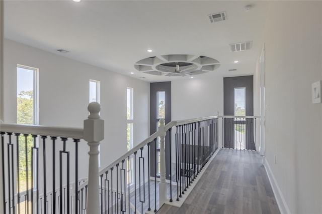 corridor featuring baseboards, visible vents, coffered ceiling, and an upstairs landing