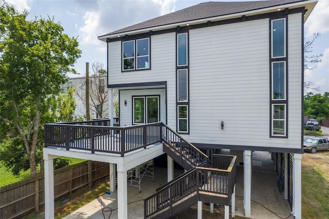 rear view of house featuring a patio, roof with shingles, stairs, fence, and a wooden deck