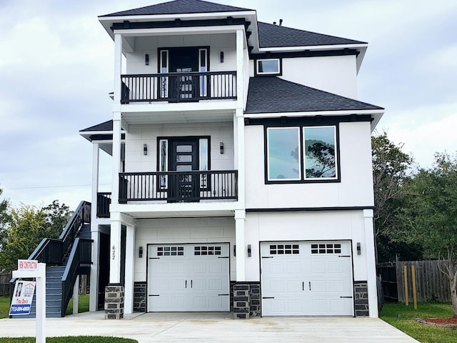 view of front of property with a balcony, a garage, driveway, stone siding, and roof with shingles