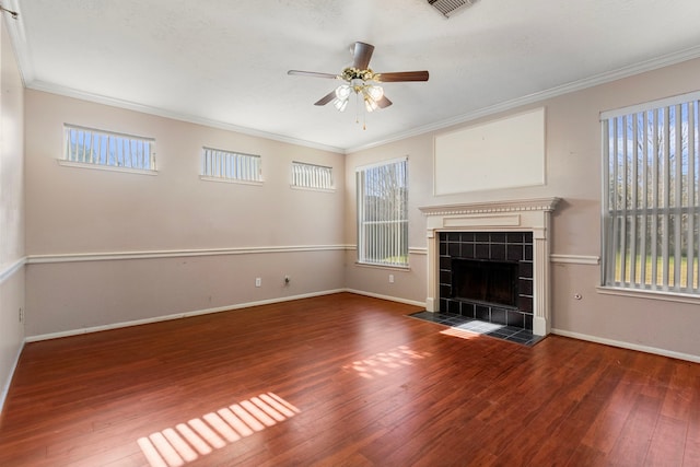 unfurnished living room featuring dark wood-type flooring, a fireplace, ornamental molding, and ceiling fan