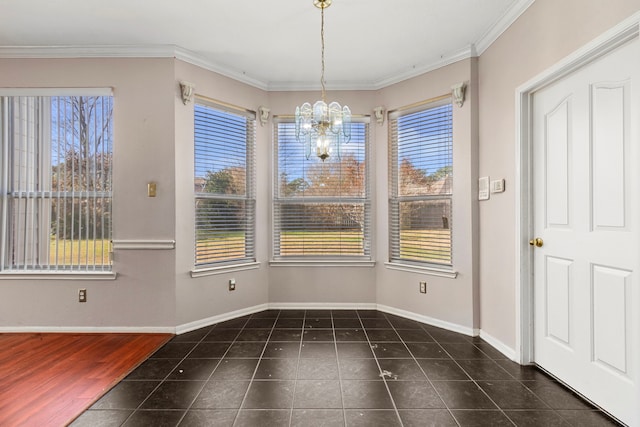 unfurnished dining area with an inviting chandelier, ornamental molding, and dark tile patterned floors