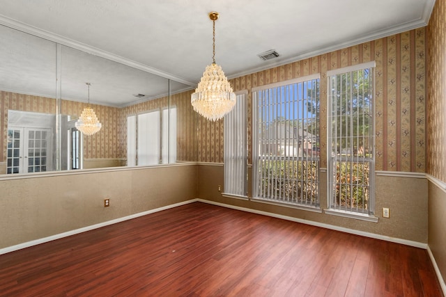 unfurnished dining area featuring crown molding, a notable chandelier, and hardwood / wood-style flooring