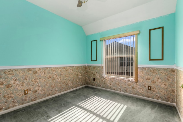 empty room with lofted ceiling, ceiling fan, and carpet