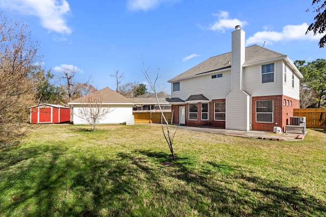 back of house with a lawn, a patio, cooling unit, and a storage shed