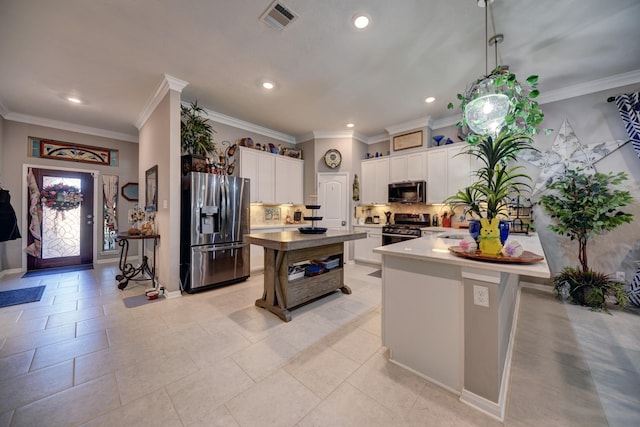 kitchen featuring white cabinetry, stainless steel appliances, hanging light fixtures, and a kitchen island