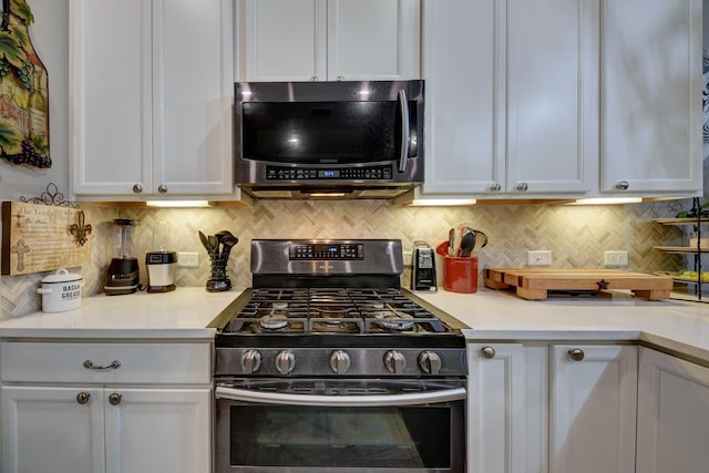 kitchen with decorative backsplash, stainless steel appliances, and white cabinets