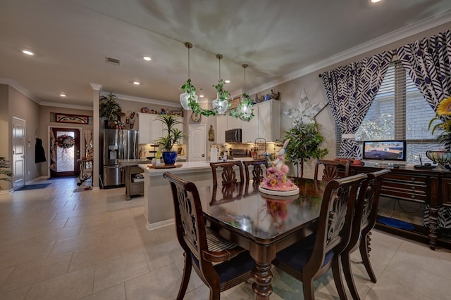 tiled dining room with decorative columns and crown molding