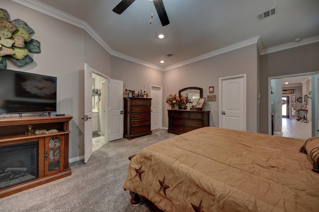 bedroom with ceiling fan, light colored carpet, ornamental molding, and ensuite bath