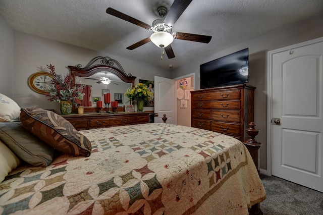 carpeted bedroom featuring ceiling fan and a textured ceiling