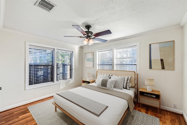 bedroom featuring crown molding, ceiling fan, a textured ceiling, and dark hardwood / wood-style flooring