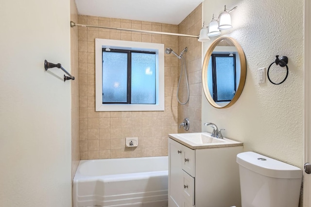 full bathroom with vanity, tiled shower / bath, and toilet