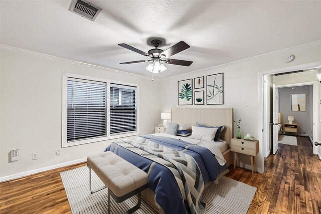 bedroom featuring crown molding, dark wood-type flooring, and ceiling fan