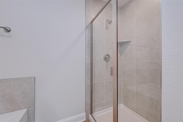 bathroom featuring a shower with door