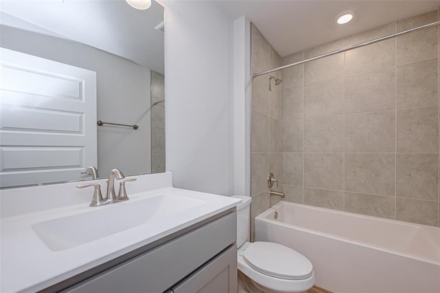 full bathroom with vanity, tiled shower / bath combo, and toilet