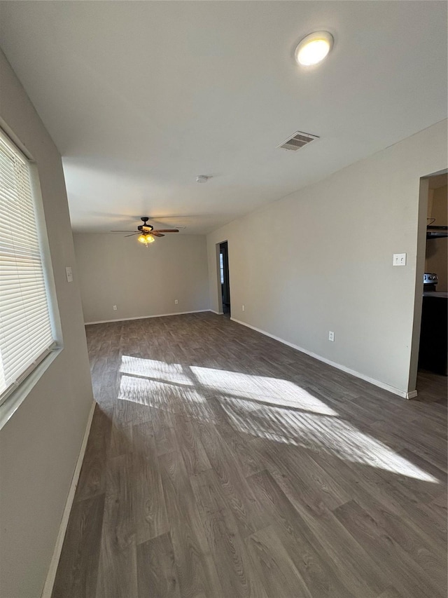 interior space with dark wood-type flooring, ceiling fan, and a wealth of natural light