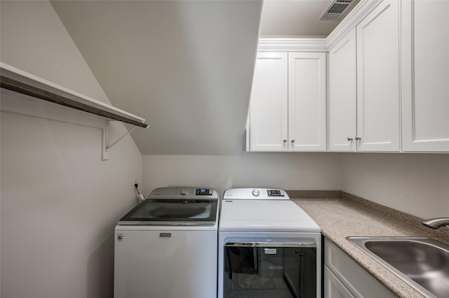 washroom with sink, cabinets, and washing machine and clothes dryer