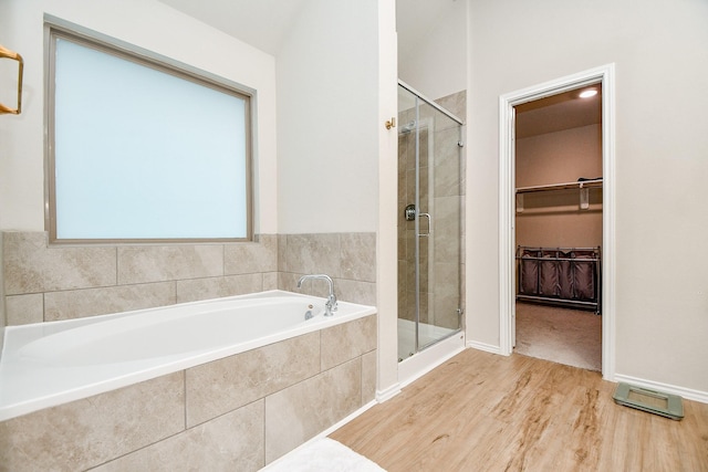 bathroom with independent shower and bath and hardwood / wood-style floors