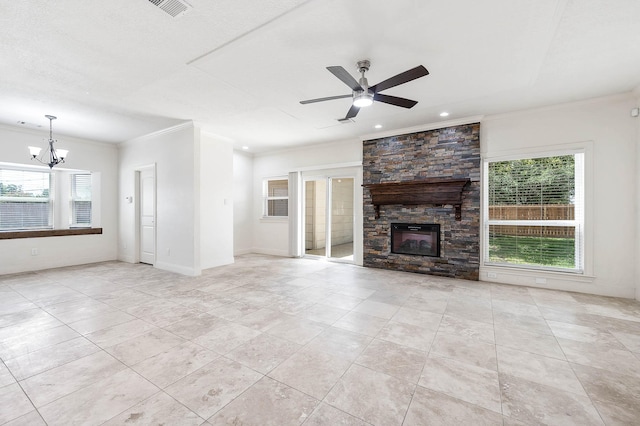 unfurnished living room featuring ornamental molding, a healthy amount of sunlight, a fireplace, and ceiling fan with notable chandelier