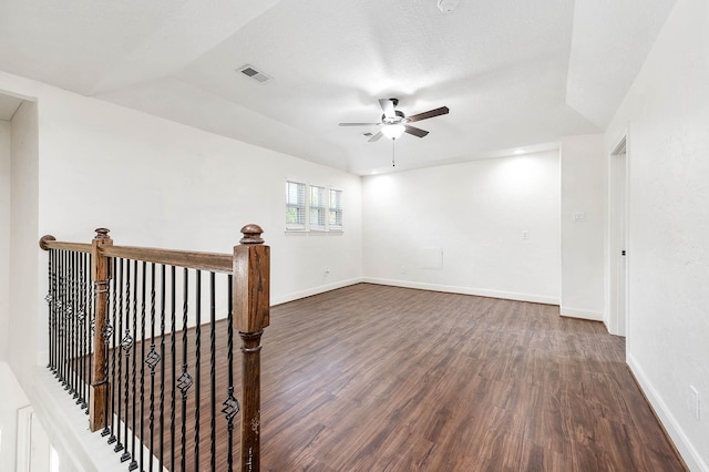 unfurnished room featuring ceiling fan, dark hardwood / wood-style floors, and a textured ceiling