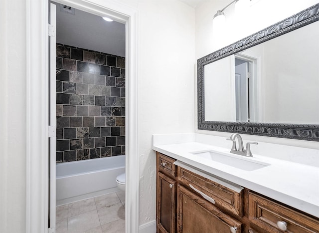 full bathroom featuring vanity, tiled shower / bath combo, tile patterned floors, and toilet