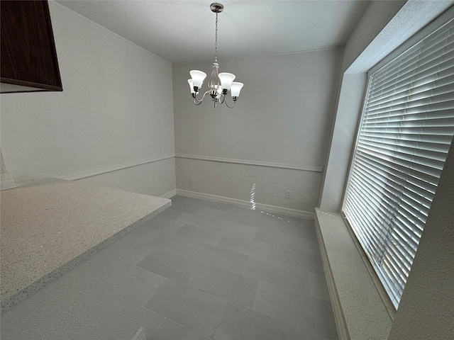 unfurnished dining area featuring a chandelier