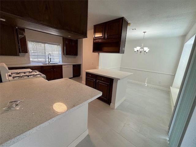 kitchen with sink, white appliances, hanging light fixtures, dark brown cabinetry, and kitchen peninsula