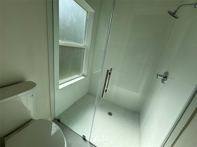 bathroom with an enclosed shower and toilet