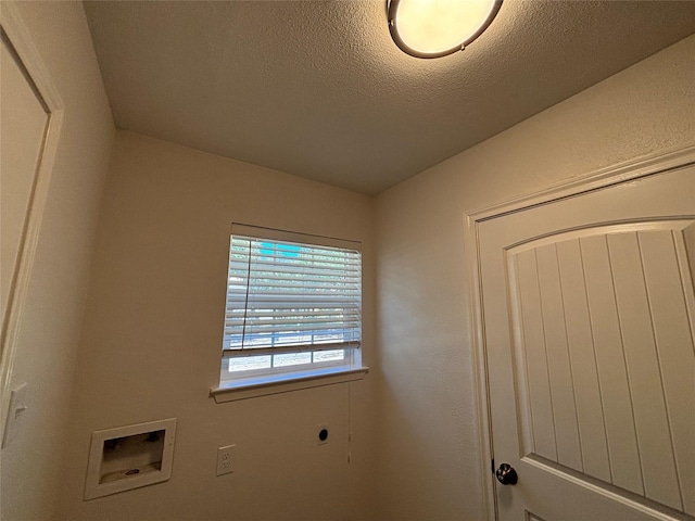 clothes washing area with electric dryer hookup, hookup for a washing machine, and a textured ceiling