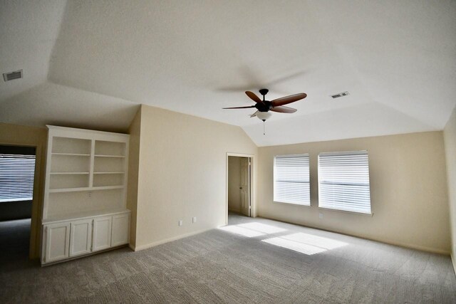 empty room with ceiling fan, light colored carpet, and vaulted ceiling