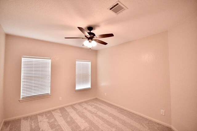 carpeted empty room with plenty of natural light and ceiling fan