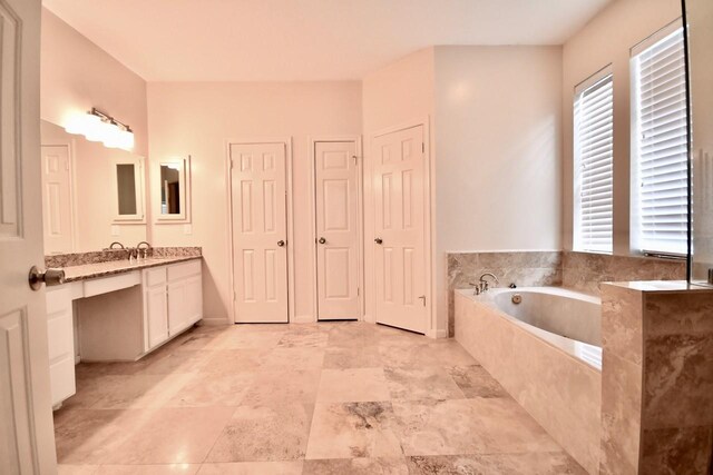 bathroom with vanity and a relaxing tiled tub