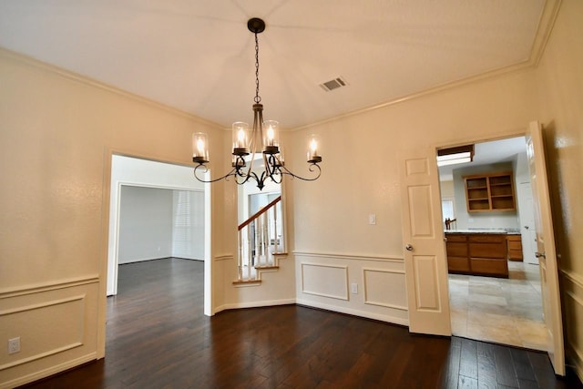 unfurnished dining area with crown molding, dark hardwood / wood-style flooring, and an inviting chandelier