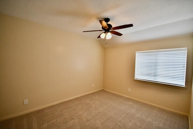 carpeted spare room with lofted ceiling, a textured ceiling, and ceiling fan