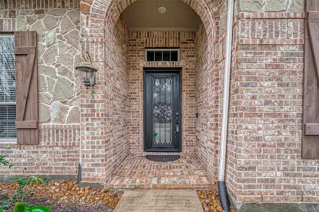 property entrance featuring brick siding