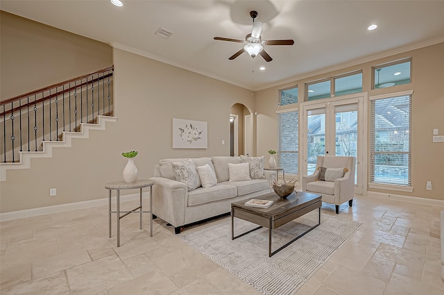 living area with baseboards, arched walkways, stairs, crown molding, and stone tile flooring