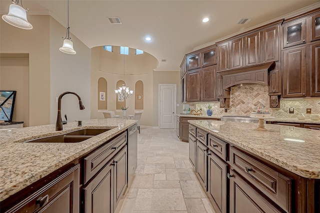 kitchen with visible vents, arched walkways, glass insert cabinets, stone tile flooring, and a sink