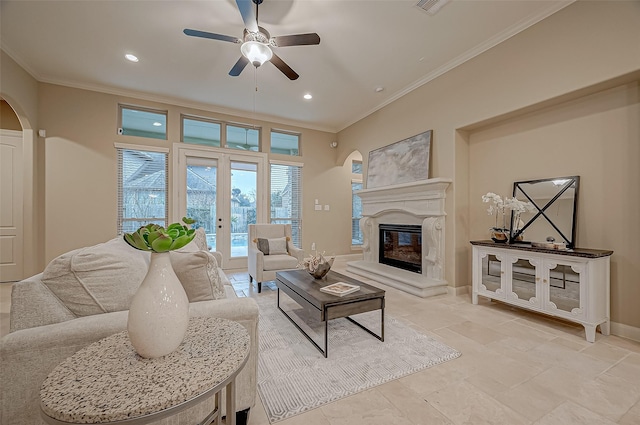 living room with arched walkways, a high end fireplace, baseboards, ornamental molding, and french doors