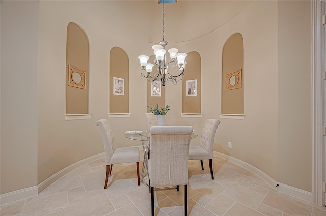 dining area featuring a chandelier and baseboards