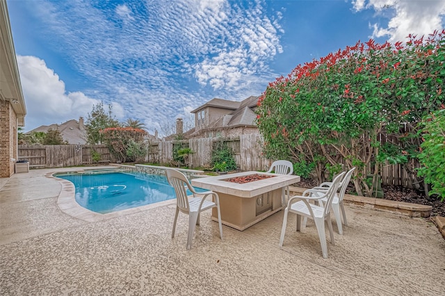 view of swimming pool with a fenced in pool, a patio area, a fenced backyard, and a fire pit