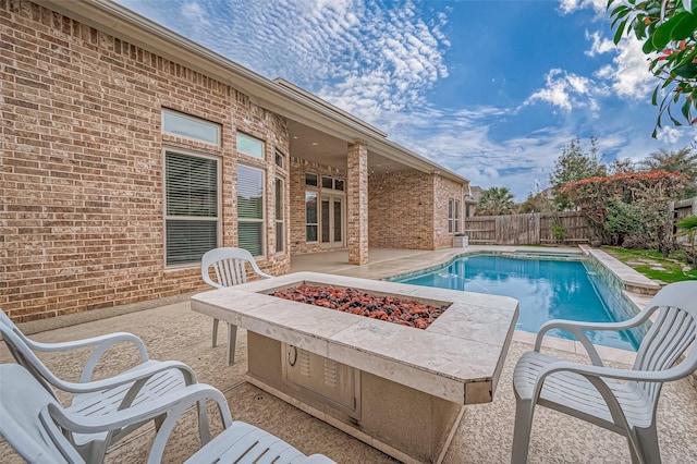 view of pool with a patio area, an outdoor fire pit, fence, and a fenced in pool