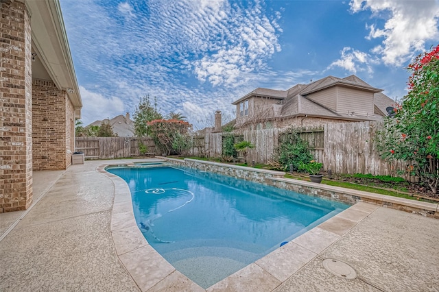 view of pool featuring a patio area, a fenced backyard, and a pool with connected hot tub