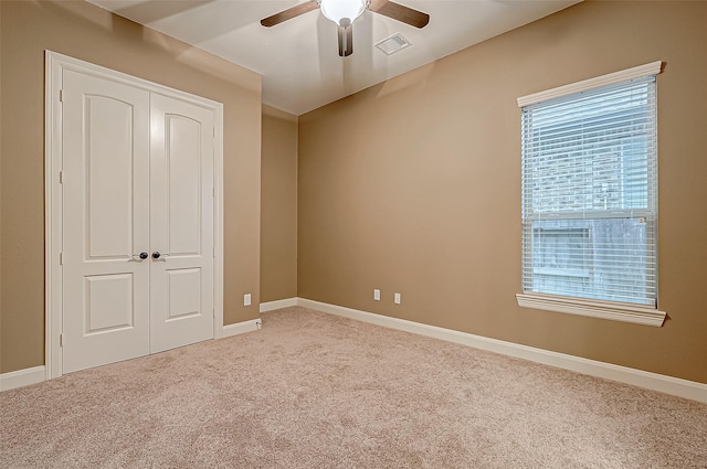 unfurnished bedroom with baseboards, a closet, visible vents, and light colored carpet