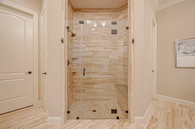 bathroom featuring wood finished floors, ornamental molding, a shower stall, and baseboards