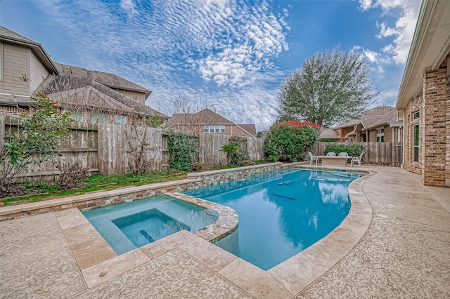 view of swimming pool featuring a patio area, a fenced backyard, and a pool with connected hot tub